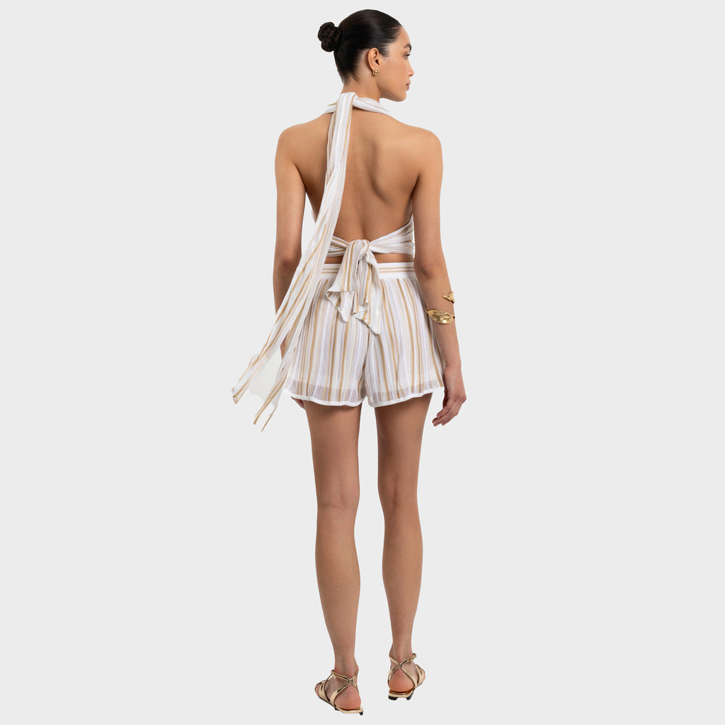 Woman wearing a striped halter top and shorts set on a white background